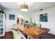 Dining room with a unique wood table, bench seating, modern art, and access to the staircase via an archway at 355 21St Ne Ave, St Petersburg, FL 33704