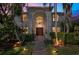 Elegant two-story home with a grand arched entrance, lush landscaping, and warm exterior lighting at 355 21St Ne Ave, St Petersburg, FL 33704