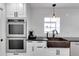 Kitchen showcases a stainless steel oven, farmhouse sink, and white cabinets with black hardware at 355 21St Ne Ave, St Petersburg, FL 33704