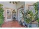 Cozy outdoor patio with terracotta tile flooring, adorned with lush plants and multiple access doors at 355 21St Ne Ave, St Petersburg, FL 33704
