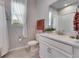 Well-lit bathroom featuring a vanity, toilet, shower and window at 3753 Maxwell Park Dr, Sun City Center, FL 33573