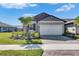Single-story home featuring a well-manicured lawn and a two-car garage, enhanced by meticulous landscaping at 3753 Maxwell Park Dr, Sun City Center, FL 33573