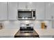 A modern kitchen features white cabinets and countertops, plus stainless steel appliances at 3753 Maxwell Park Dr, Sun City Center, FL 33573
