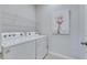 Clean laundry area featuring a white washer, dryer, and wire shelving for organized storage at 3753 Maxwell Park Dr, Sun City Center, FL 33573