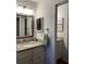 Bathroom vanity with granite countertop, framed mirror, and modern lighting fixtures at 3911 La Costa Ln, Largo, FL 33771