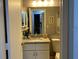 Bathroom vanity with granite countertop, framed mirror, and modern lighting fixtures at 3911 La Costa Ln, Largo, FL 33771