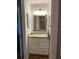 Bathroom vanity with granite countertop, white cabinets, framed mirror, and modern lighting fixtures at 3911 La Costa Ln, Largo, FL 33771