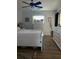 Bedroom with wood floors, white furniture, and a large window providing natural light at 3911 La Costa Ln, Largo, FL 33771