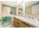 Bright bathroom featuring a double sink vanity with modern fixtures and a unique shower curtain at 420 64Th Ave # 907, St Pete Beach, FL 33706