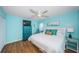 Airy bedroom featuring wood floors and a king bed with charming coastal decor and a ceiling fan at 420 64Th Ave # 907, St Pete Beach, FL 33706