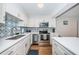 Updated kitchen with white cabinetry, stainless steel appliances, and attractive backsplash at 420 64Th Ave # 907, St Pete Beach, FL 33706