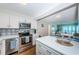 Modern kitchen featuring stainless appliances, white cabinets, and seamless flow into the living area at 420 64Th Ave # 907, St Pete Beach, FL 33706