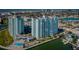 Aerial view showcasing waterfront condo community amenities: pool, lounge area, shuffleboard court and marina at 420 64Th Ave # 907, St Pete Beach, FL 33706
