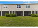 Exterior view of the townhome's back showing the lawn and screened patios at 4212 Cloud Hopper Way, Lutz, FL 33559