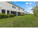 A view of the townhomes from the back, featuring a lush lawn and screened patio areas at 4212 Cloud Hopper Way, Lutz, FL 33559