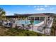 Community pool area featuring ample lounge seating, a covered pavilion, and lush landscaping at 4212 Cloud Hopper Way, Lutz, FL 33559