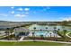 Community pool area including pool, pool house, lounging chairs, lake, and palm trees at 4212 Cloud Hopper Way, Lutz, FL 33559
