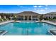 Community pool with steps leading into the clear water and pool furniture for lounging around at 4212 Cloud Hopper Way, Lutz, FL 33559