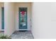 Charming front door with glass panes and a decorative heart wreath at 4212 Cloud Hopper Way, Lutz, FL 33559