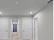 Hallway with multiple doors and neutral paint is spacious and functional at 4212 Cloud Hopper Way, Lutz, FL 33559