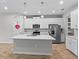 Modern kitchen features white cabinets, stainless steel appliances, and large island at 4212 Cloud Hopper Way, Lutz, FL 33559