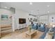 Cozy living room featuring modern decor, comfortable blue furnishings, and an open layout to the kitchen at 4212 Cloud Hopper Way, Lutz, FL 33559
