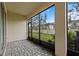 Screened-in patio with stone flooring provides a view of the backyard and surrounding landscape at 4212 Cloud Hopper Way, Lutz, FL 33559