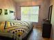 Bedroom featuring a large window, wood-look tile flooring, and modern dresser at 4275 Castlebridge Ln # 1325, Sarasota, FL 34238