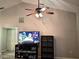 Living room featuring a fan, an entertainment center with NFL, and a white door at 4275 Castlebridge Ln # 1325, Sarasota, FL 34238