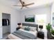 Modern bedroom features a ceiling fan, mounted TV, walk-in closet, and black nightstands on each side of the bed at 434 Albatross Rd, Rotonda West, FL 33947