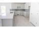 Bright kitchen features gray cabinets, tile backsplash, stainless steel sink, and tile floors at 434 Albatross Rd, Rotonda West, FL 33947