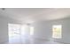 Bright living room features tile floors, white walls, three windows, and sliding glass doors at 434 Albatross Rd, Rotonda West, FL 33947