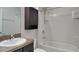 A well-lit bathroom with a shower-tub combination and a wooden cabinet above the toilet at 4719 Lindever Ln, Palmetto, FL 34221