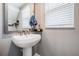 Bathroom featuring a pedestal sink, large mirror, with soap and towel and a window with white blinds at 4849 Isola Ct, Wesley Chapel, FL 33543