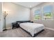 This bedroom features neutral walls and carpet and side tables and two windows for natural light at 4849 Isola Ct, Wesley Chapel, FL 33543