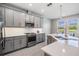 This is a bright kitchen with gray cabinets, stainless steel appliances, and a spacious island overlooking a lake at 4849 Isola Ct, Wesley Chapel, FL 33543