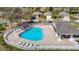 Aerial view of a bright blue community pool with lounge chairs and a covered seating area at 5237 Gato Del Sol Cir, Wesley Chapel, FL 33544