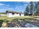 Backyard with a simple patio and mature trees bordering the property line at 564 Florida S Cir, Apollo Beach, FL 33572