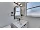 Modern bathroom with sleek vanity, geometric sink, and dark arched mirror at 564 Florida S Cir, Apollo Beach, FL 33572