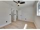 Modern bedroom with light hardwood floors, ceiling fan, and access to the bathroom and closet for added convenience at 564 Florida S Cir, Apollo Beach, FL 33572