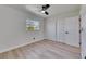 Bright bedroom featuring new wood floors, ceiling fan, closet, and window view at 564 Florida S Cir, Apollo Beach, FL 33572