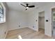 Well-lit bedroom featuring a ceiling fan, light hardwood flooring, and a spacious closet for ample storage at 564 Florida S Cir, Apollo Beach, FL 33572