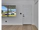 Bright entryway featuring laminate wood floors and a modern white door at 564 Florida S Cir, Apollo Beach, FL 33572