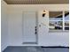 Close-up of a white front door with modern hardware and house number at 564 Florida S Cir, Apollo Beach, FL 33572