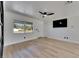 Spacious living room with light wood floors, a ceiling fan, and a view of the front yard at 564 Florida S Cir, Apollo Beach, FL 33572