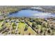 Aerial view of waterfront homes surrounded by lush greenery and the sparkling blue lake at 5914 Fitzgerald Rd, Odessa, FL 33556
