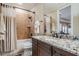 Updated bathroom features modern fixtures, custom vanity, granite countertops, and tiled shower with tub at 5914 Fitzgerald Rd, Odessa, FL 33556