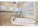This bathroom boasts a large soaking tub, walk-in shower, and double windows for plenty of natural light at 5914 Fitzgerald Rd, Odessa, FL 33556