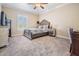 Comfortable bedroom features a decorative ceiling fan, plush carpeting, and natural light at 5914 Fitzgerald Rd, Odessa, FL 33556