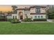 Elegant two-story home featuring a tile roof, manicured landscaping, and arched entryway at 5914 Fitzgerald Rd, Odessa, FL 33556